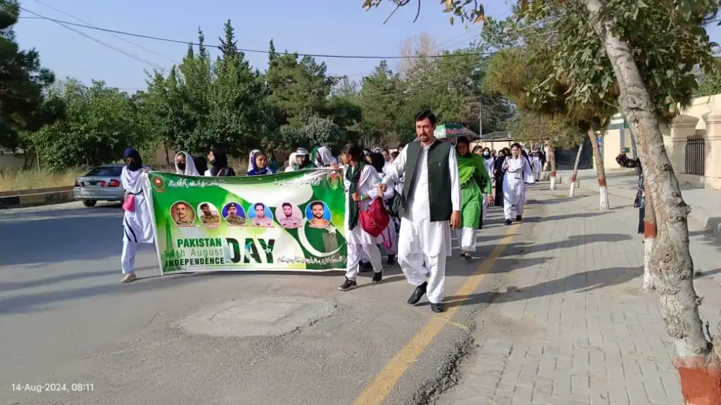 FGBDC Quetta students celebrating Pakistan Independence Day parade with a banner and national pride.
